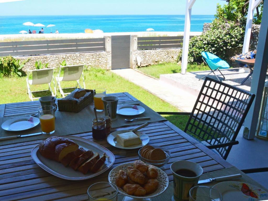 a table with food on it with a view of the beach at Amazing beach house in Chorefto