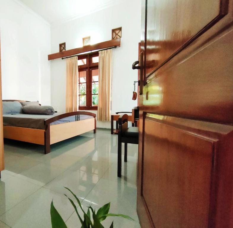 a bedroom with a bed and a wooden door at Ayodya Inn , Yogyakarta Lodging , Digital Nomads , Entrepreneurs Centre , CoWorking Space , CoLiving , Kost Lengkap , Exclusive Boarding House and Student Accommodation in Jogjakarta City Center ! in Yogyakarta