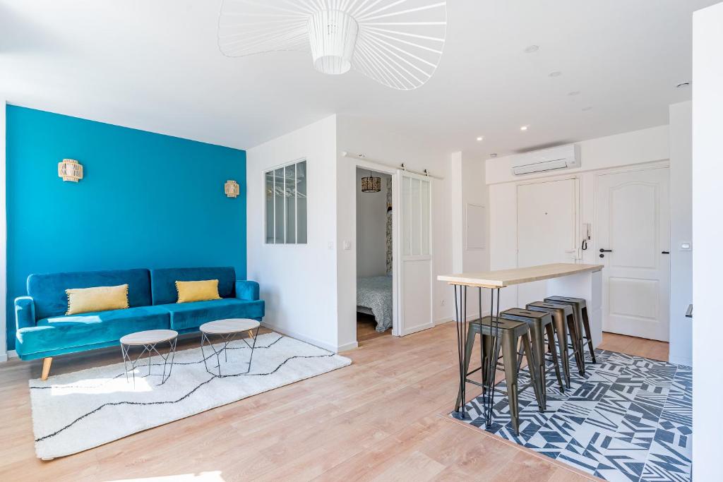 a living room with a blue couch and a table at Confortable T2 climatisé - Canebière &amp; Vieux-Port in Marseille