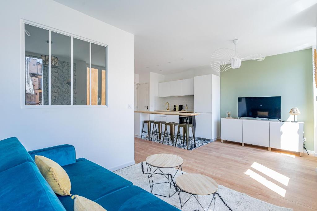 a living room with a blue couch and a kitchen at Confortable T2 climatisé - Canebière &amp; Vieux-Port in Marseille