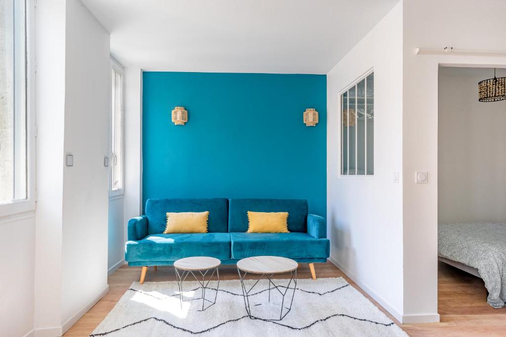 a blue couch in a living room with a blue wall at Confortable T2 climatisé - Canebière &amp; Vieux-Port in Marseille