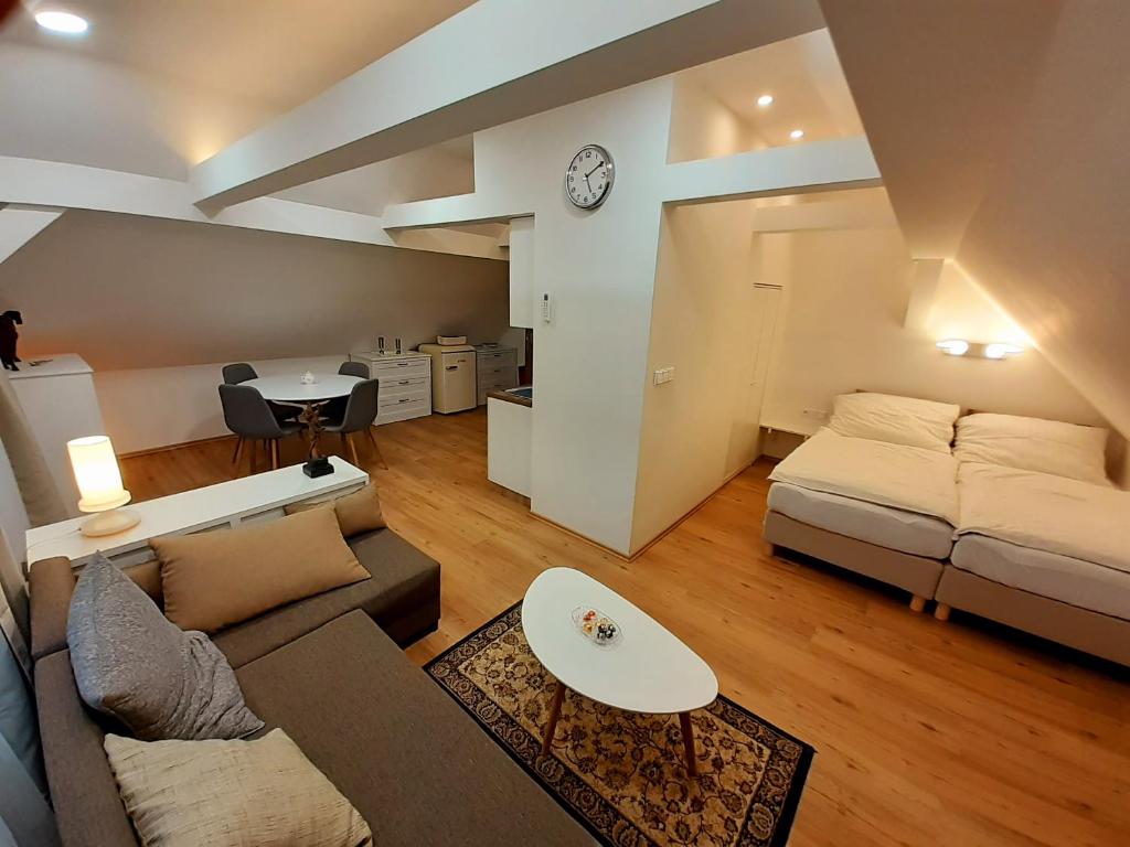 ein Wohnzimmer mit einem Sofa und einem Tisch in der Unterkunft Apartmány v centru - Lázně Kynžvart in Lázně Kynžvart