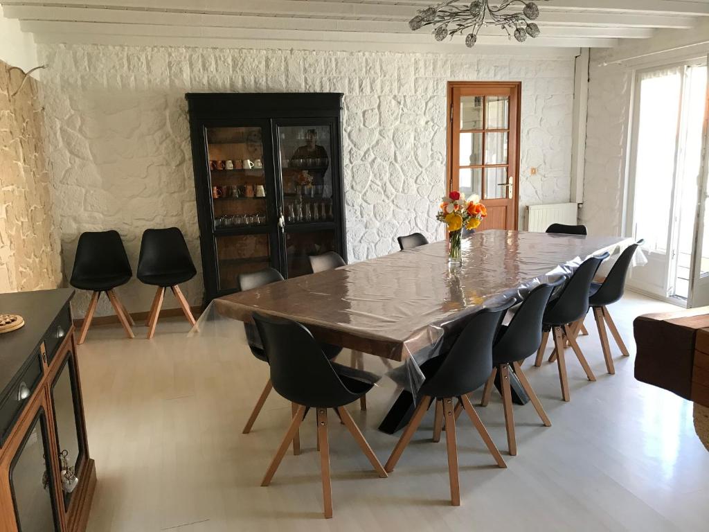 a dining room with a large table and chairs at Longère entre terre et mer in Marquise