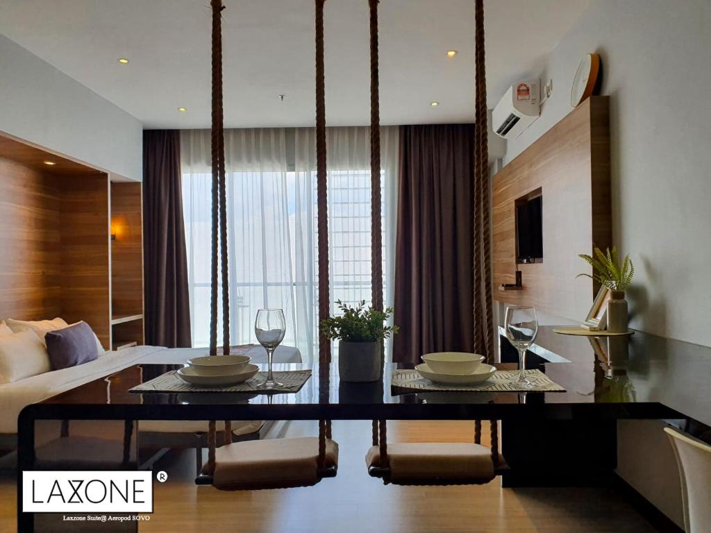 uma sala de estar com uma mesa de jantar e um quarto em Aeropod Sovo Studio - Laxzone Suite em Kota Kinabalu