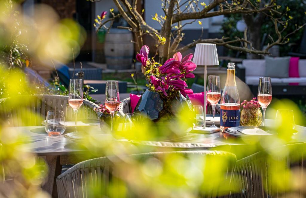 einen Tisch mit Gläsern Wein und eine Vase Blumen in der Unterkunft Landgasthaus & Hotel zur Krone in Dahn