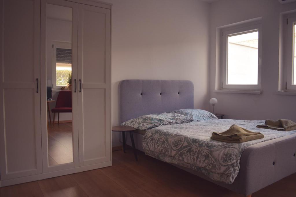 a bedroom with a bed and a window and a mirror at See Appartements in Mörbisch am See