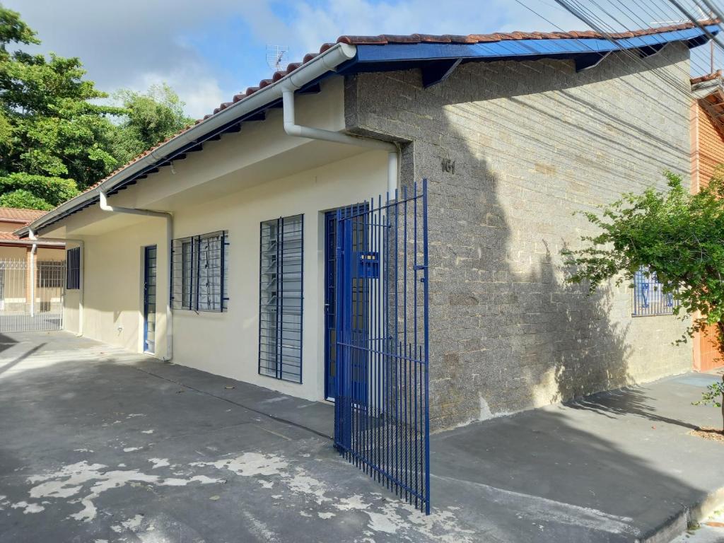 un bâtiment avec une porte bleue sur son côté dans l'établissement Casa Caraguatatuba no Centro, à Caraguatatuba