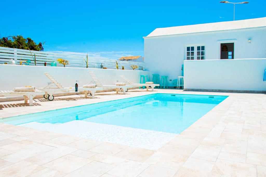 una piscina frente a una casa blanca en Turquesa Beach&Pool Apartaments, en Playa Honda