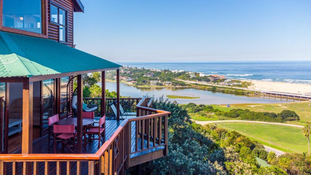 a balcony of a house with a view of the beach at Boardwalk Lodge – Self-Catering in Wilderness