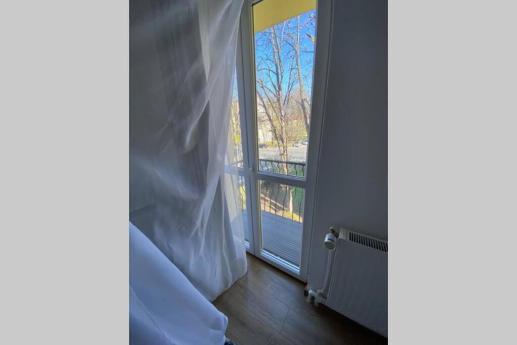 a room with a sliding glass door with a window at Cozy apartment in the Business area of Bucharest in Bucharest