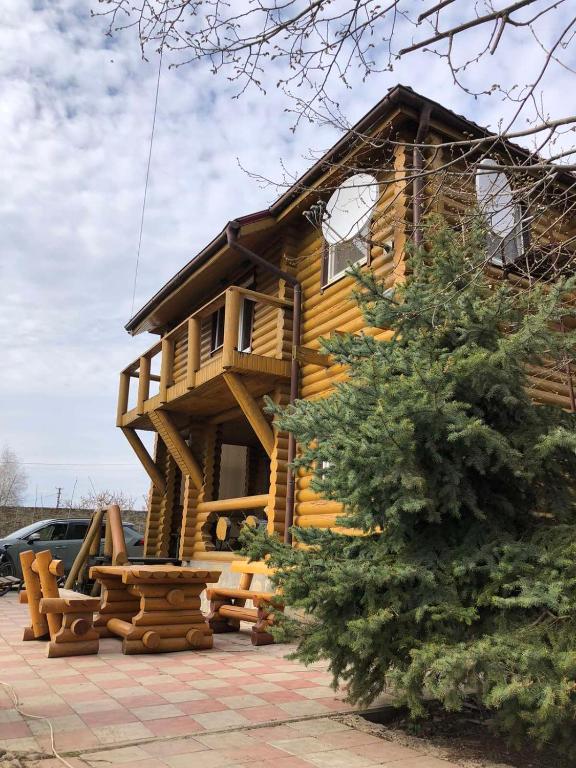 einem Blockhaus mit einer Bank davor in der Unterkunft Загородный дом , сруб , рыбалка , баня , отдых , река , лес in Troitskoye