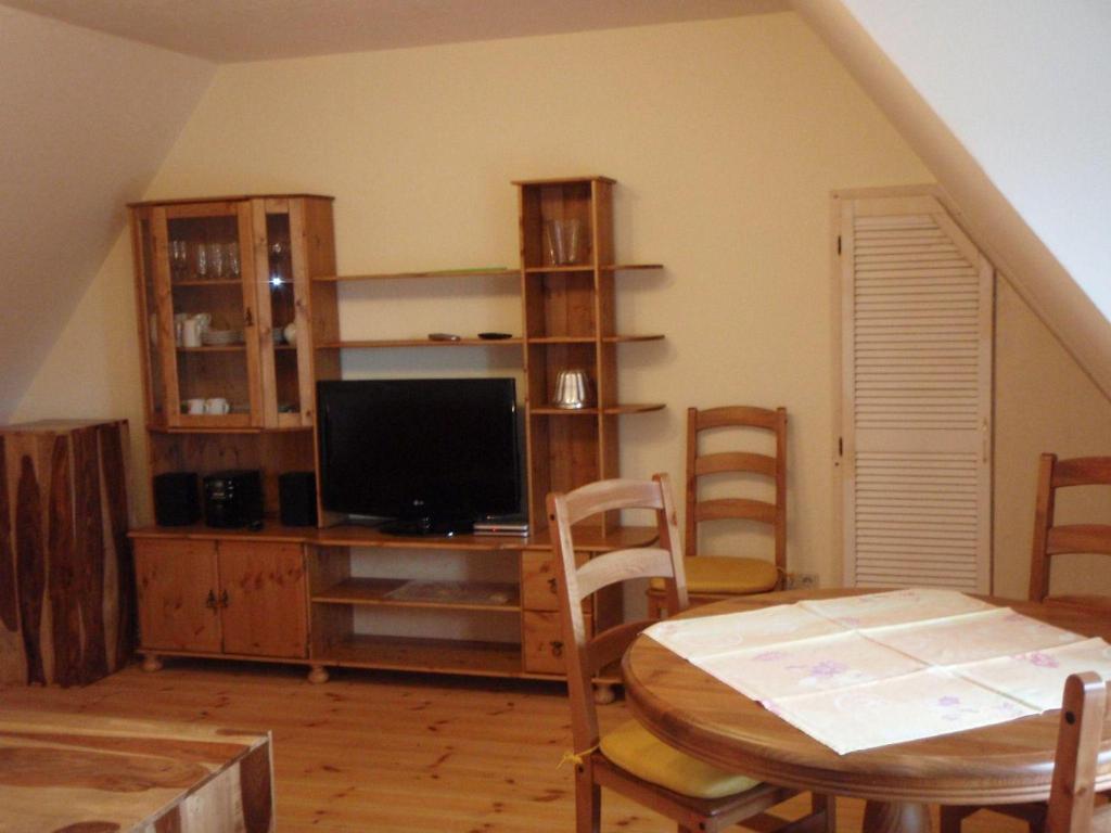 ein Wohnzimmer mit einem TV, einem Tisch und Stühlen in der Unterkunft Schleisicht in Winnemark