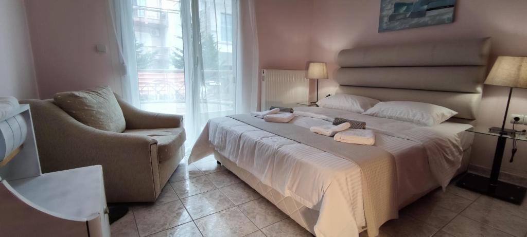 ein Schlafzimmer mit einem großen weißen Bett und einem Stuhl in der Unterkunft Lucy's next to sea apartment in Keramotí