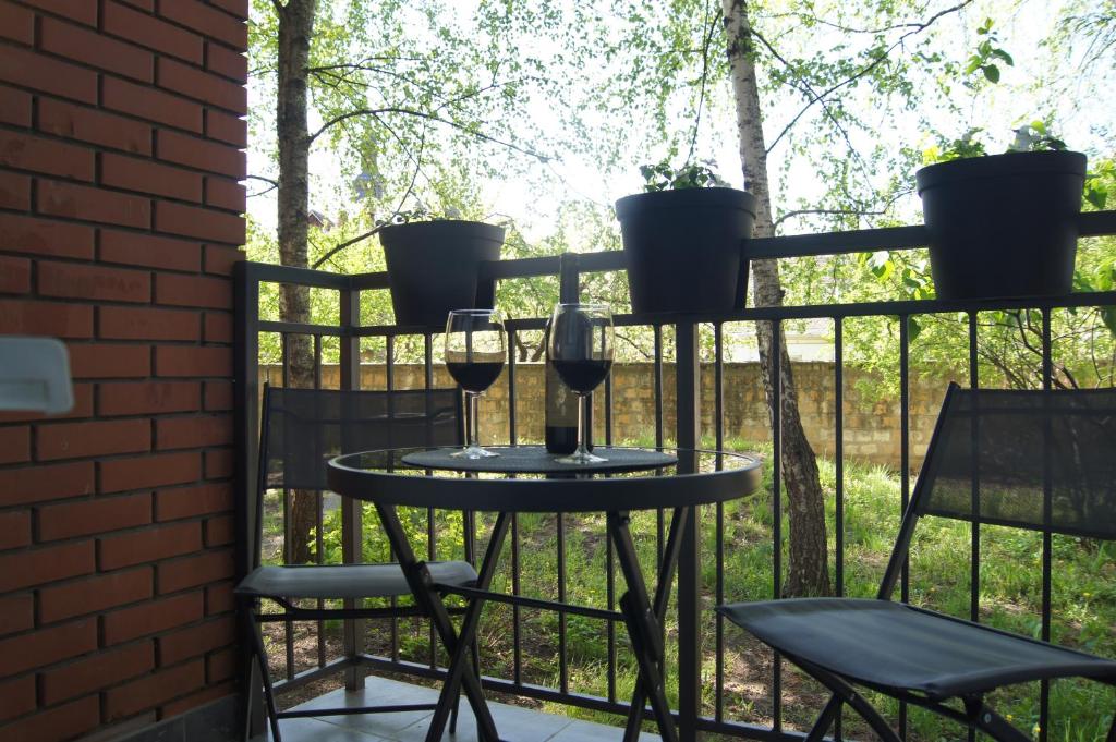 a table with two glasses of wine and two chairs at Apartman Una in Sremski Karlovci