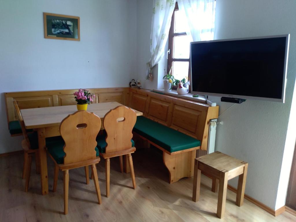 Bergruhe في Sankt Ruprecht ob Murau: غرفة طعام مع طاولة وكراسي وتلفزيون بشاشة مسطحة