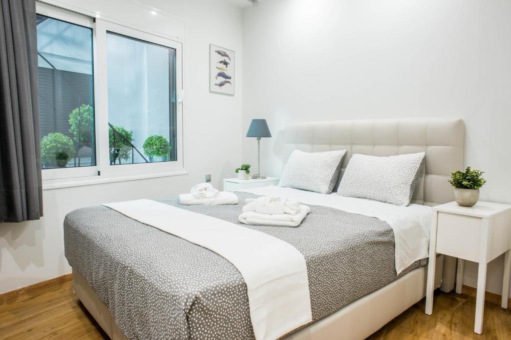 ein weißes Schlafzimmer mit einem Bett und einem Fenster in der Unterkunft Α26 Pristine & modern flat near Monastiraki square in Athens in Athen