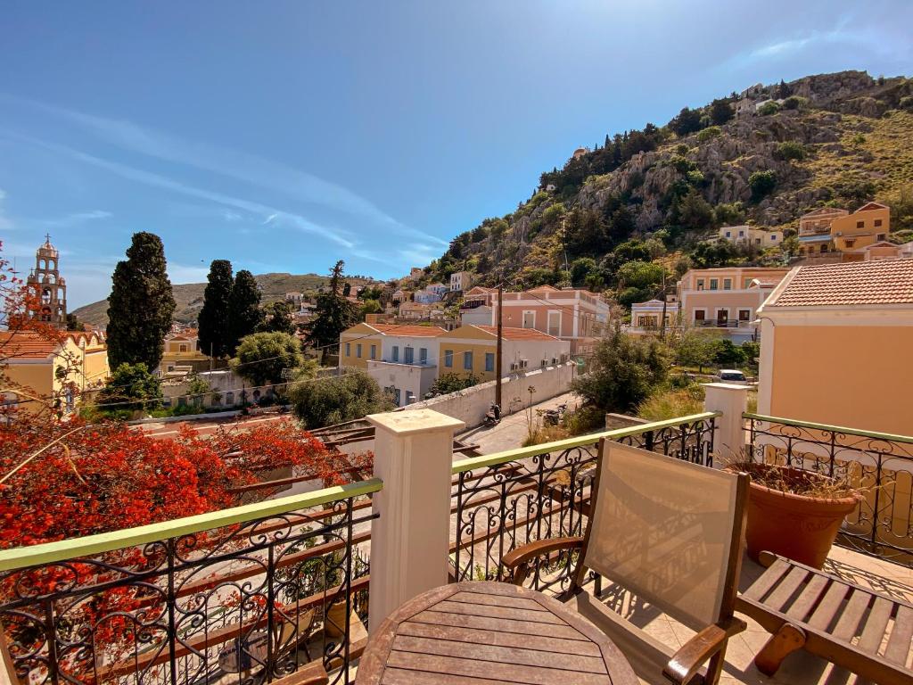 a balcony with a bench and a view of a city at Symi Garden Studios in Symi