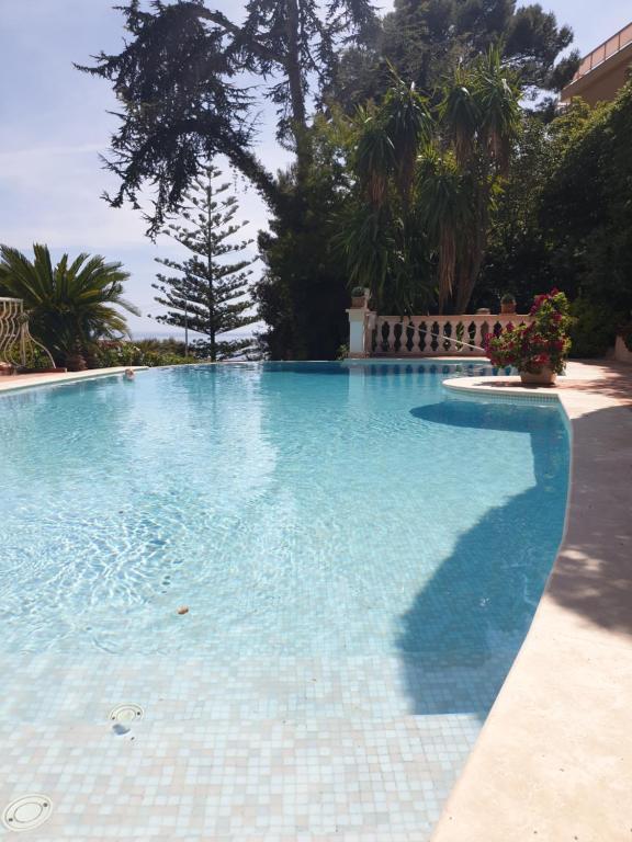 uma grande piscina com água azul em Villa Silhouette Cap d'Ail em Cap d'Ail