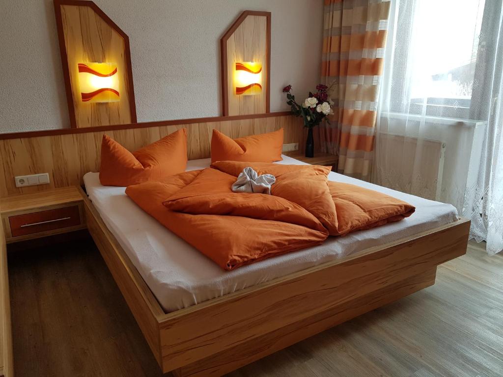 a large bed with orange pillows in a bedroom at Familienferienhaus Florentine in Längenfeld