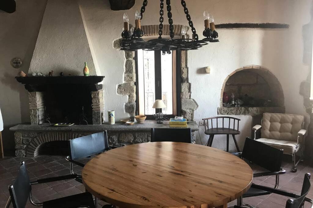 sala de estar con mesa de madera y chimenea en Residenza Monastero de' Medici, en Bolsena