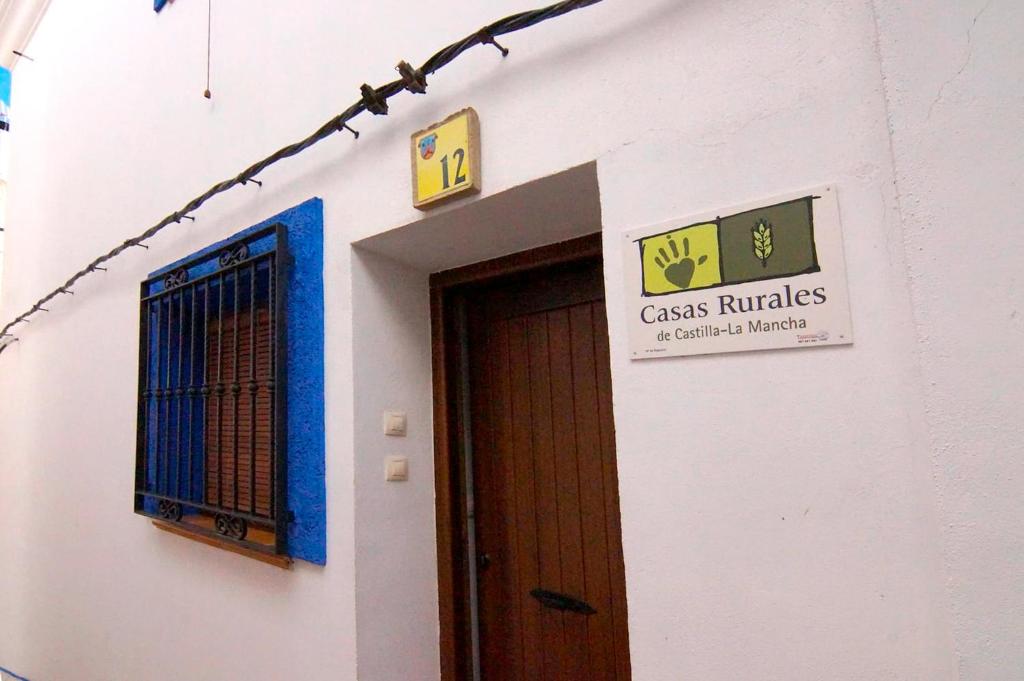 a sign on the side of a building with a door at Casa Rural San Marcos in Yeste
