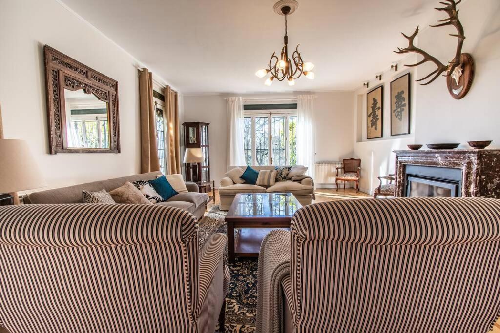 ein Wohnzimmer mit 2 Sofas und einem Kamin in der Unterkunft Preciosa Villa de Campo / Wonderful Country Villa in San Agustín de Guadalix