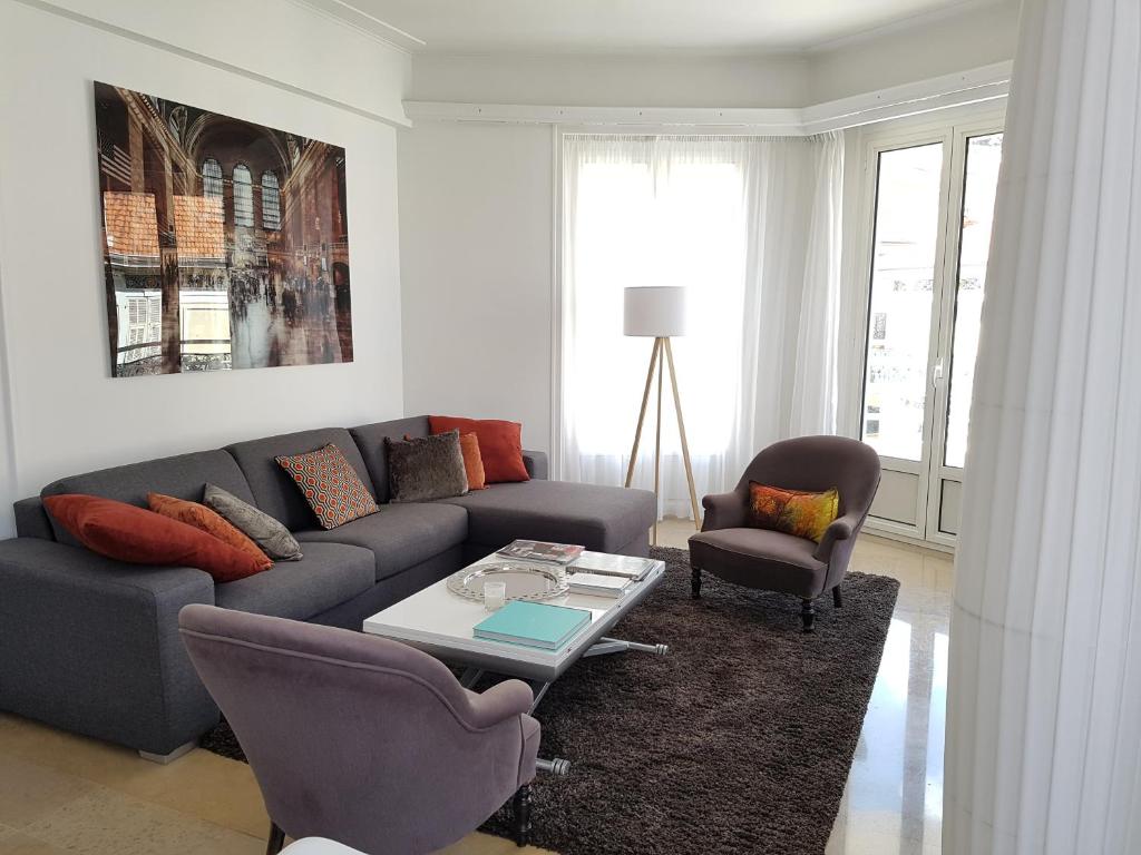 Appartement Centre ville carré d'Or في مونت كارلو: غرفة معيشة مع أريكة وكرسيين وطاولة