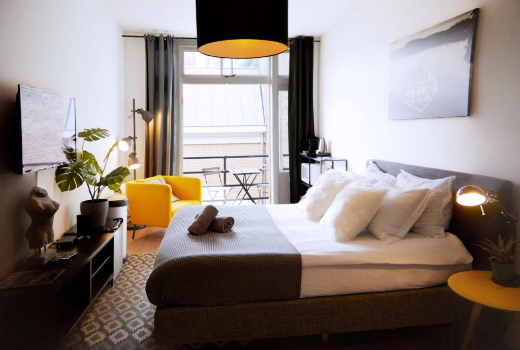 um quarto com uma cama grande e uma cadeira amarela em Modern Hideout Ace Location em Amsterdã