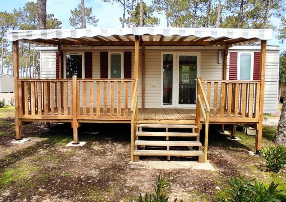 une petite maison avec une terrasse couverte et une terrasse dans l'établissement Les Dunes de Contis, à Saint-Julien-en-Born