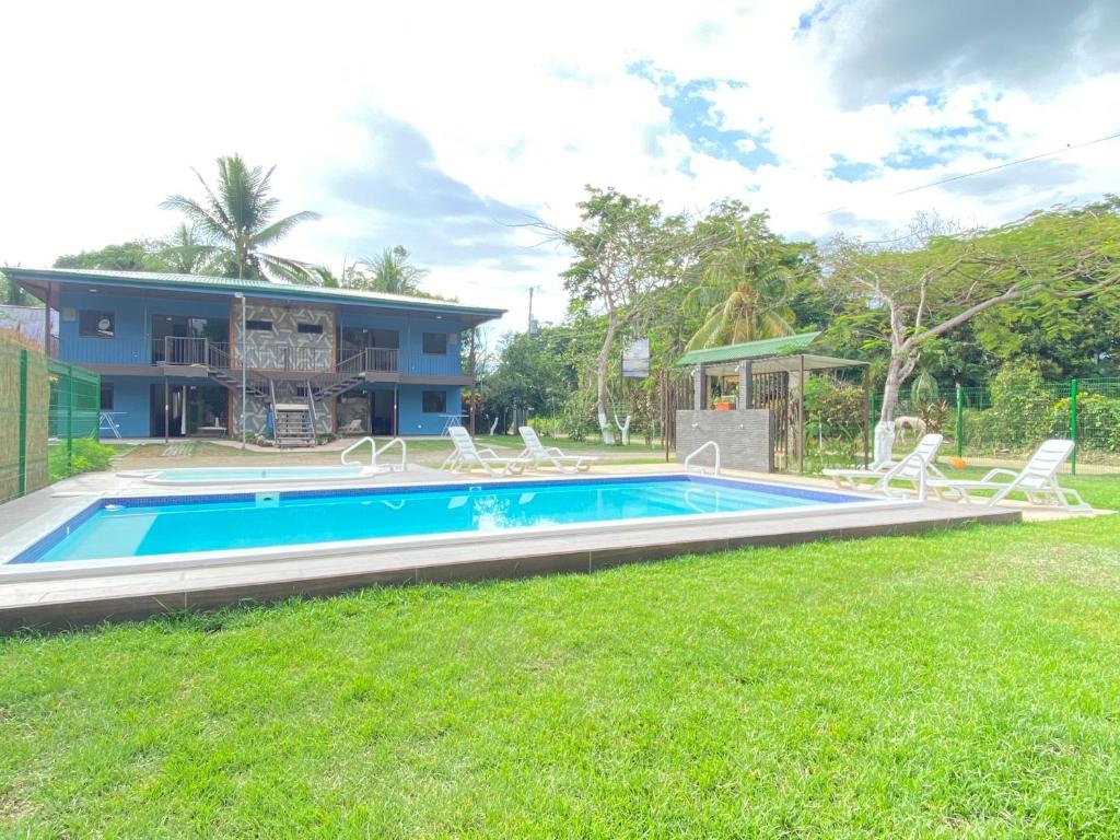 a swimming pool in the yard of a house at Cabinas El Paso de Moisés in Uvita