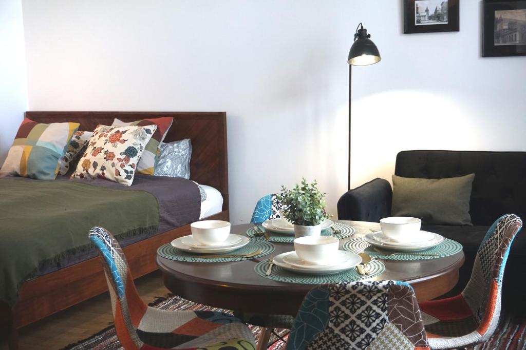 a living room with a table with chairs and a bed at Apartament pod Tężnią II in Głuchołazy