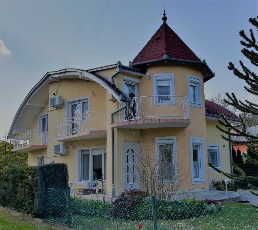 a large yellow house with a round turret at Apartman Mercédesz II. in Zalakaros