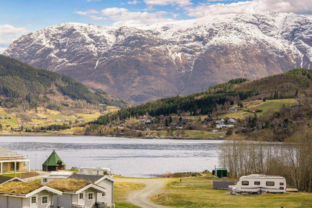 a view of a lake and mountains with a house at Ulvik Camping in Ulvik