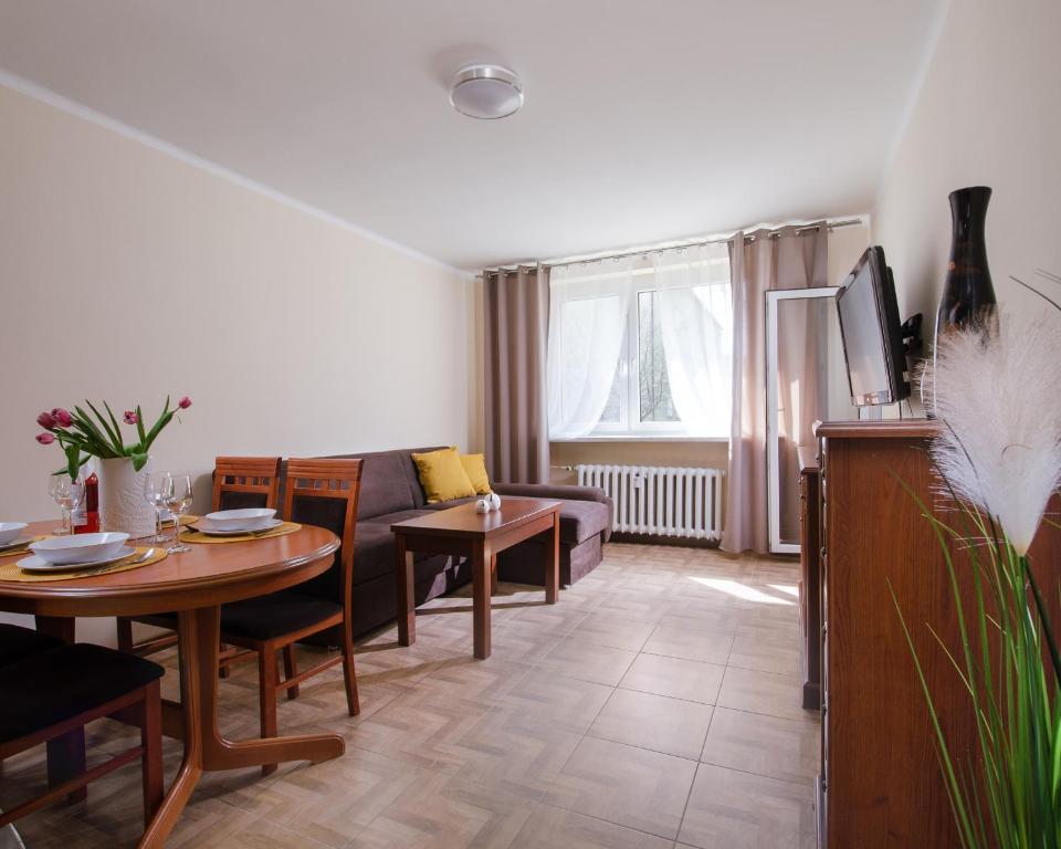 - un salon avec une table et un canapé dans l'établissement Apartament Deluxe Arcon Double, à Siemianowice Śląskie