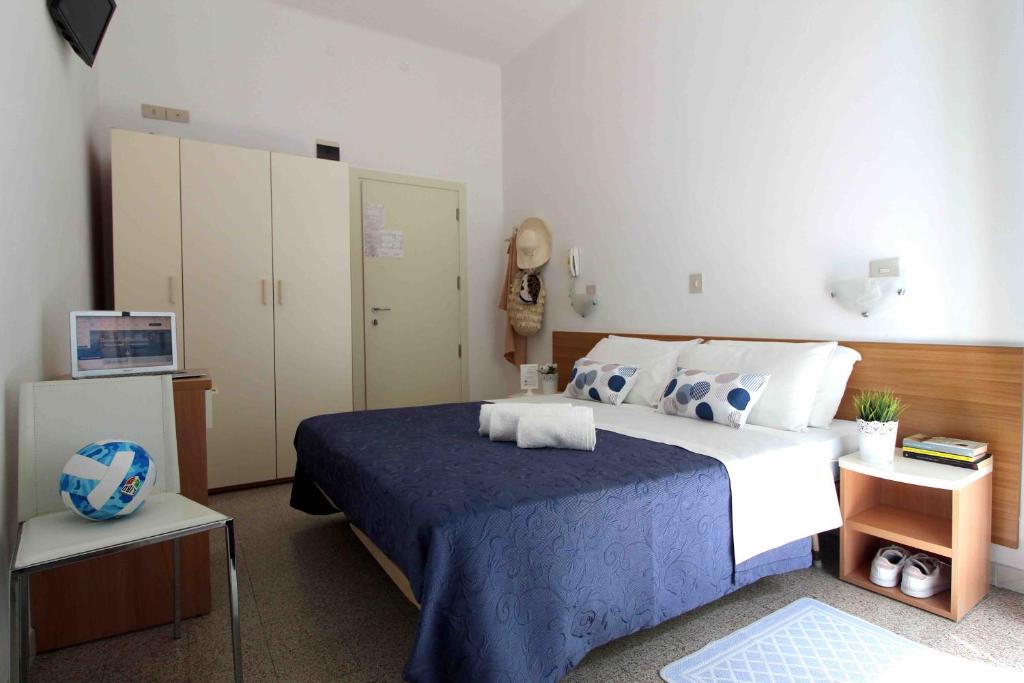 リミニにあるHotel Kellyのベッドルーム(青と白のベッド1台、テレビ付)