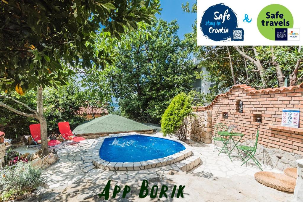 a pool in a yard with a sign that says hr bank at Apartments Borik Crikvenica in Crikvenica