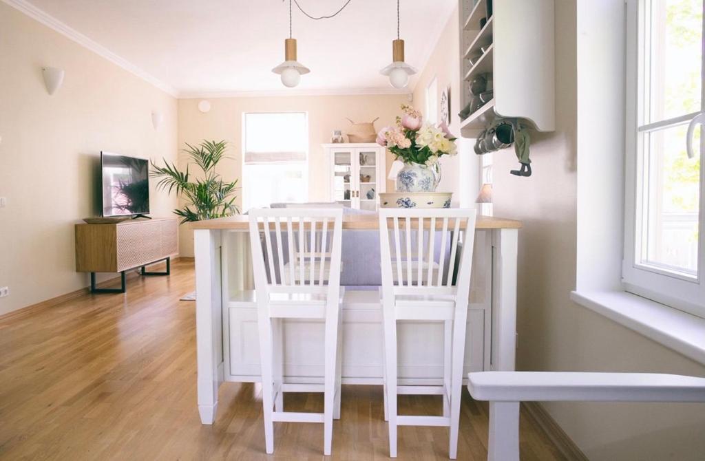 una cucina con tavolo e due sedie bianche di Linnuse Apartement a Haapsalu