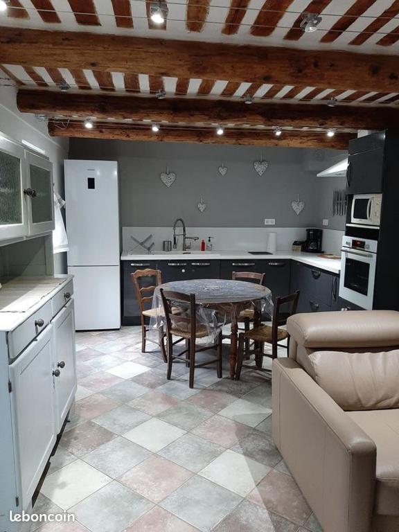 a kitchen with a table and a kitchen with a couch at Gite au cœur du Luberon in Goult