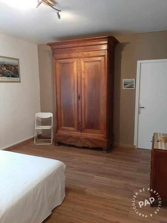 a bedroom with a wooden cabinet and a bed at Gite au cœur du Luberon in Goult
