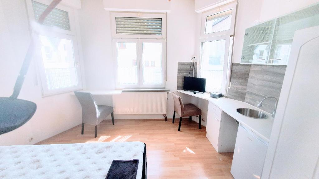 een badkamer met een wastafel en een bureau met een computer bij FMI9Accomation Raunheim in Raunheim