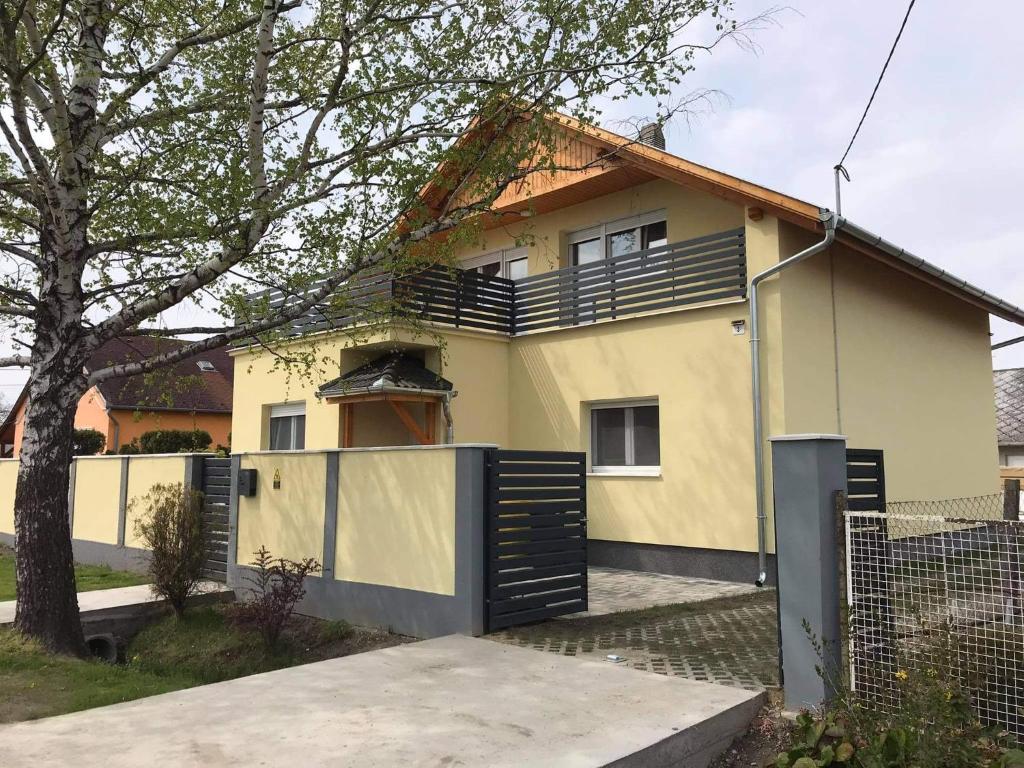 una casa con una puerta y una valla en Duma Home en Balatonkeresztúr