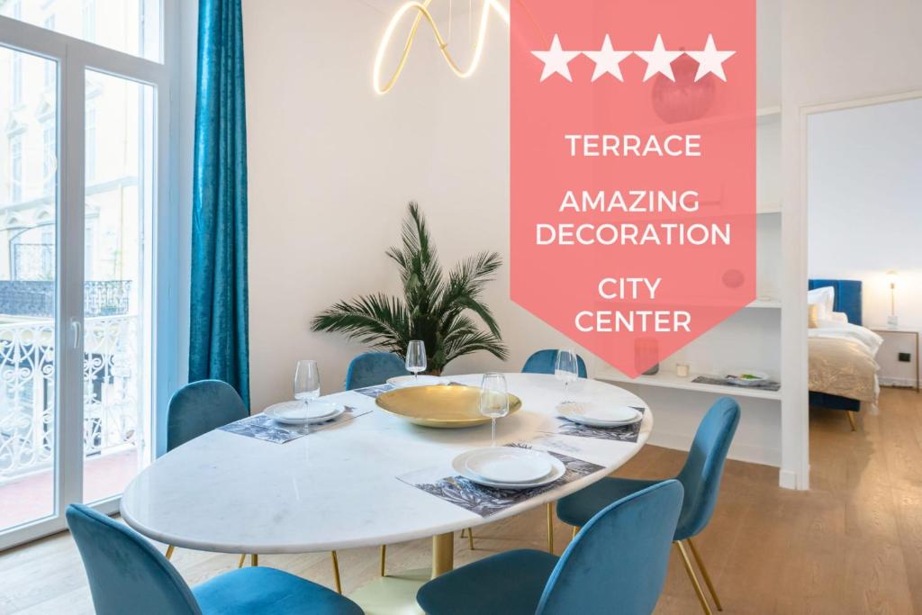 une salle à manger avec une table blanche et des chaises bleues dans l'établissement Modern 2-Br Apartment in the Heart of Cannes, à Cannes