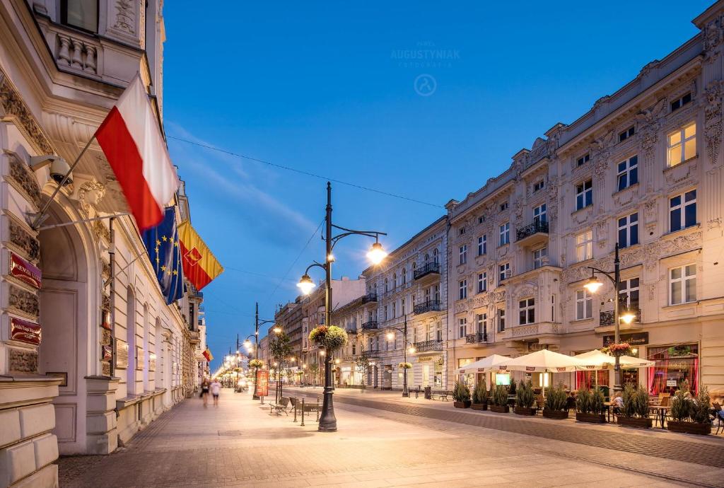a street in a city at night with buildings at Royal Aparthotel Piotrkowska 33 in Łódź