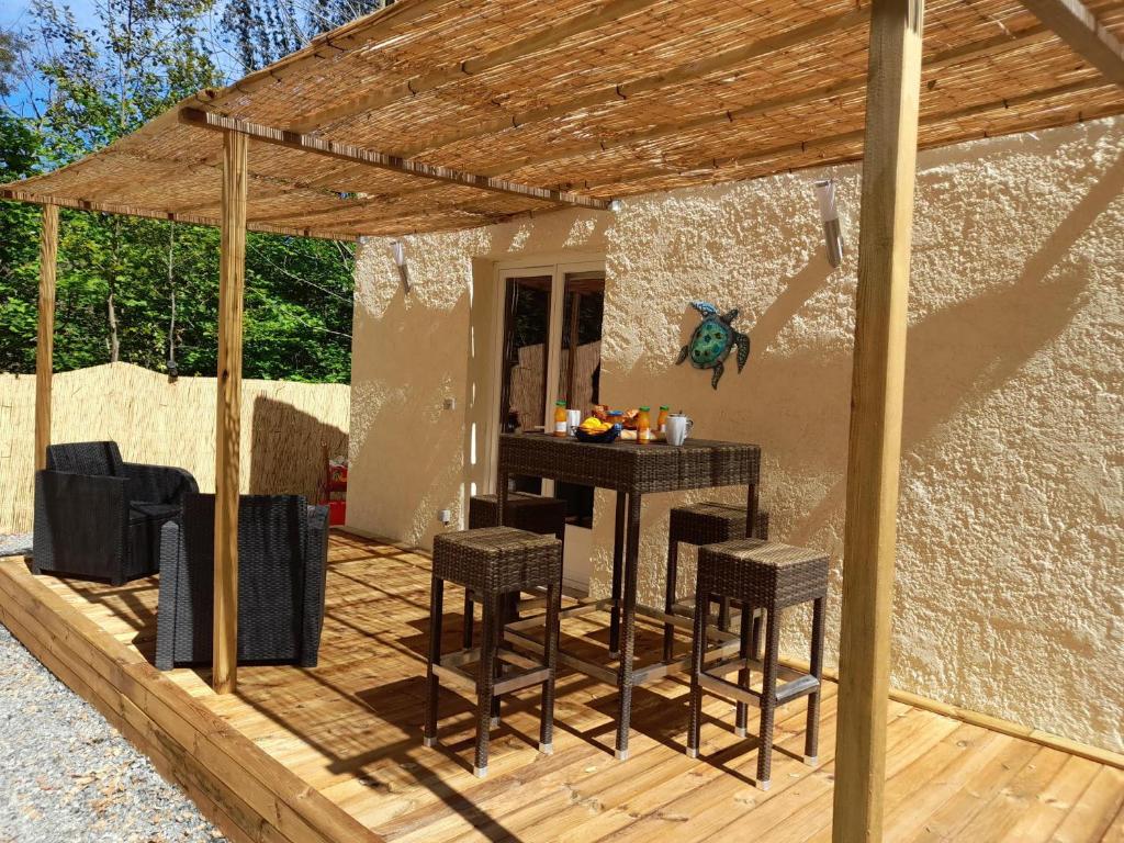 a patio with a table and chairs in a house at Maisonnette A Santa Ghjulia entre Mer & Montagne in Volpajola