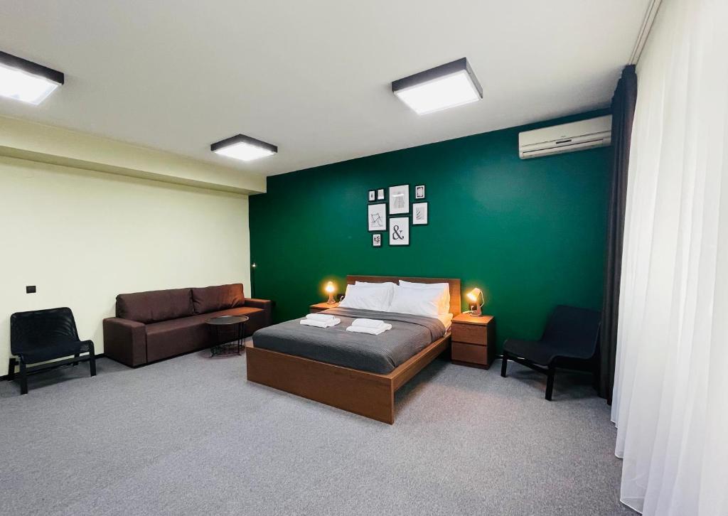 ソチにあるGuest House Four Roomsの緑の壁、ベッド付きのベッドルーム1室