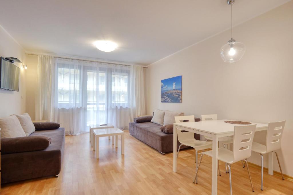 sala de estar con mesa y sofá en Apartment Sand Castle with free parking, en Świnoujście