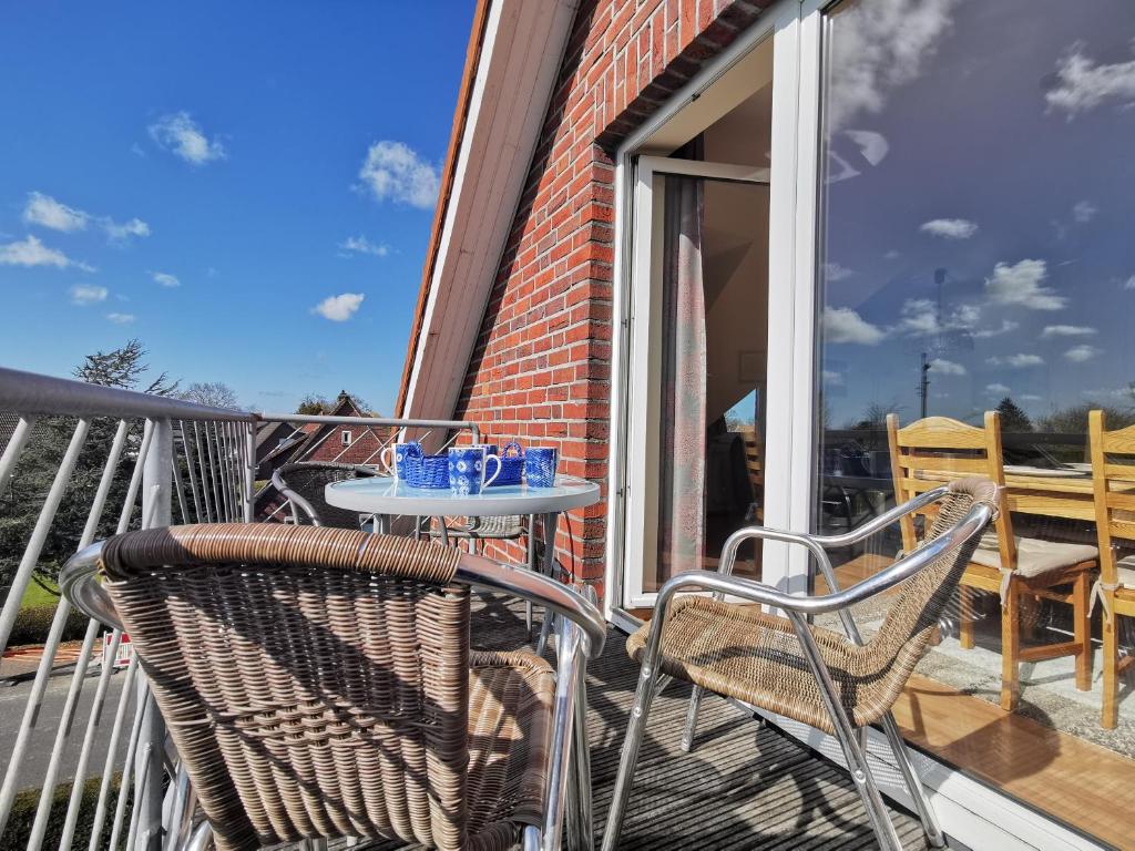 a patio with two chairs and a table on a balcony at Strandbad in Horumersiel