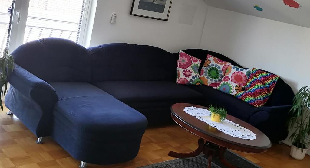 a blue couch in a living room with a table at at Marian's place in Spuhlja