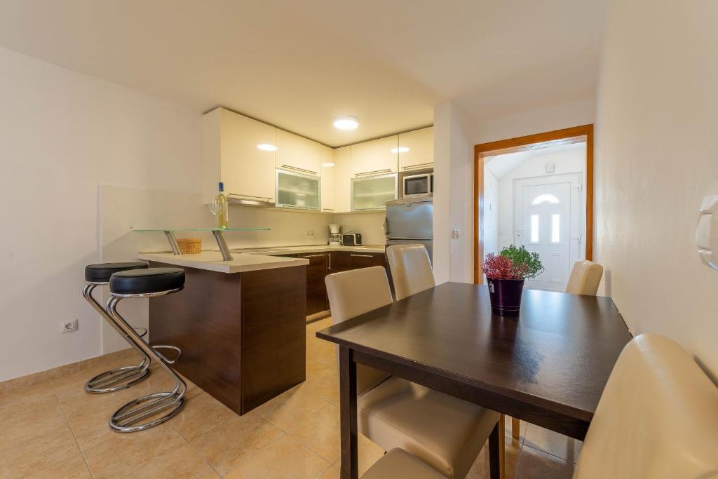 kuchnia i jadalnia ze stołem i krzesłami w obiekcie Niko Apartment w mieście Vir