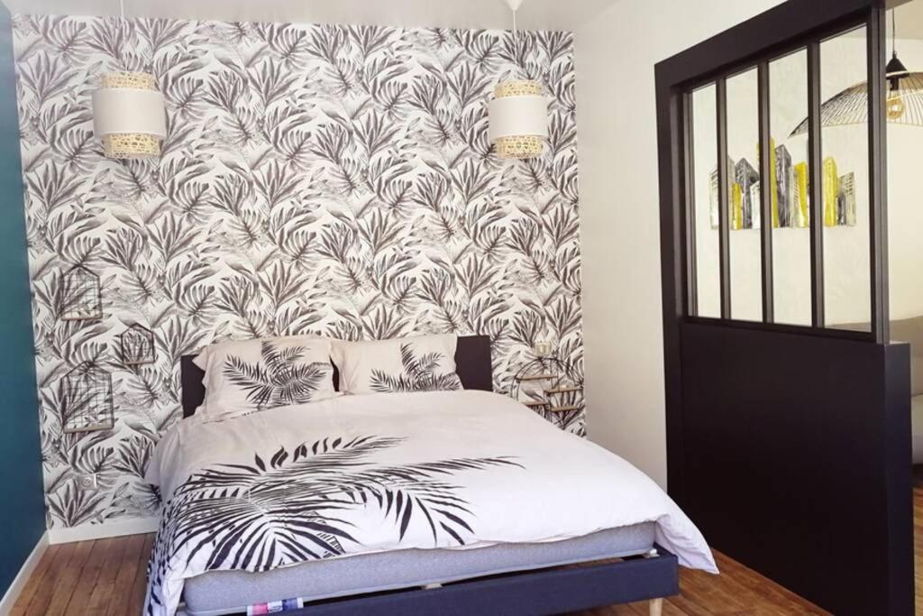 1 dormitorio con 1 cama con papel pintado en blanco y negro en L'oasis : Appartement en centre ville, en Abbeville